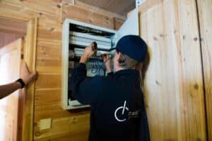 Bildet viser en elektriker fra M Carlsen & sønn som jobber med et sikringssakp