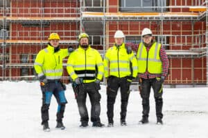 bildet viser fire menn i gule vester
